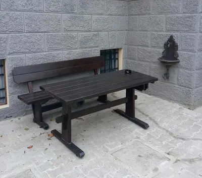 a wooden bench sitting in front of a wall at Apartment Lan in Homec