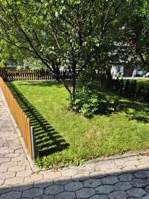 a park with a fence and trees and grass at Karavanke Holiday Getaway in Hrušica