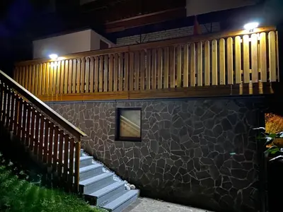 a building with stairs and a fence at night at Karavanke Holiday Getaway in Hrušica