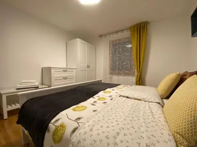 a bedroom with a bed and a desk and a window at Karavanke Holiday Getaway in Hrušica