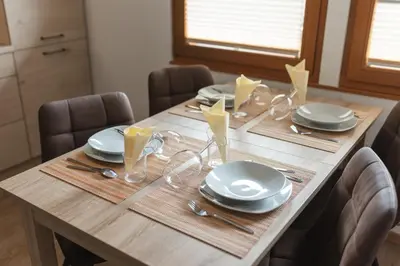a wooden table with plates and dishes on it at Karavanke Holiday Getaway in Hrušica
