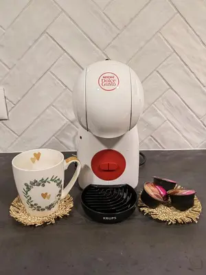a coffee maker sitting next to a cup on a table at Home-in apartma in Ljubljana