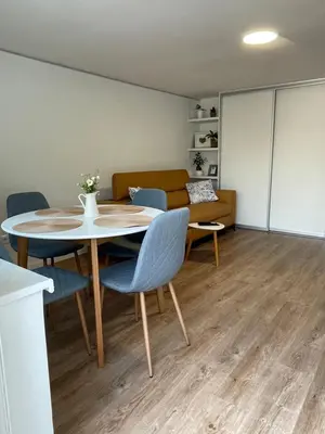 a living room with a table and chairs and a couch at Home-in apartma in Ljubljana