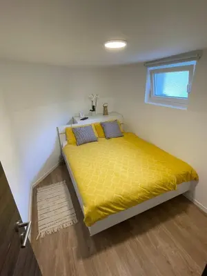 a bedroom with a bed with yellow sheets and a window at Home-in apartma in Ljubljana
