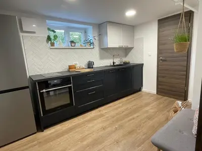 a kitchen with black cabinets and a counter top at Home-in apartma in Ljubljana