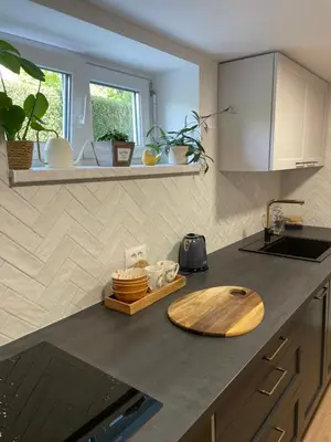 a kitchen with a wooden cutting board on a counter at Home-in apartma in Ljubljana