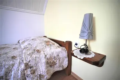 a bedroom with a bed with a lamp on a table at Kmetija Podobnik in Idrija