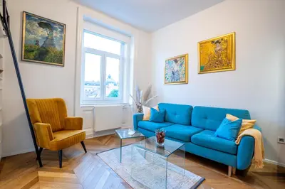 a living room with a blue couch and a chair at Downtown Luxury Retreat in Ljubljana