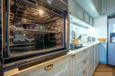 an oven in a kitchen with white cabinets at Downtown Luxury Retreat in Ljubljana