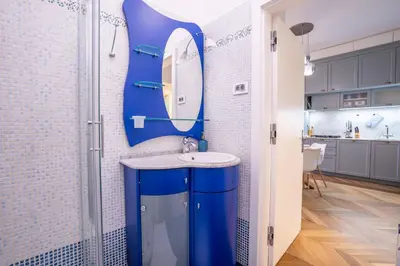 a bathroom with a blue sink and a mirror at Downtown Luxury Retreat in Ljubljana