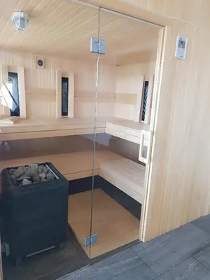 a sauna with a glass door in a room at Vila Frigo Olimia in Podplat