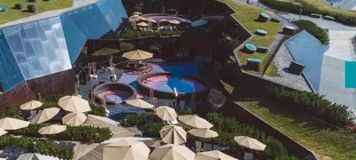 an aerial view of a resort with a pool and umbrellas at Vila Frigo Olimia in Podplat