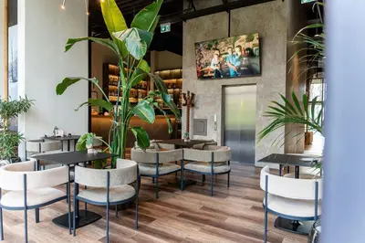 a restaurant with tables and chairs and plants at Hotel Lonca in Škofja Loka