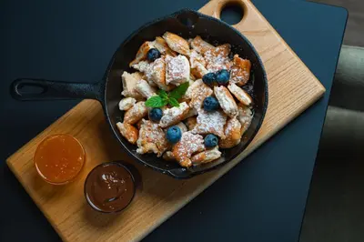 a cast iron skillet filled with food on a wooden board at Hotel Lonca in Škofja Loka