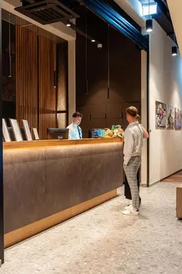 two people standing at a counter in a restaurant at Hotel Lonca in Škofja Loka