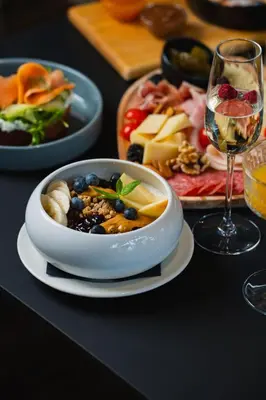 a table with a bowl of food and a glass of wine at Hotel Lonca in Škofja Loka