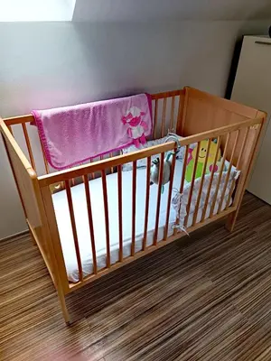 a crib with a purple blanket on top of it at Riverside Guesthouse in Ig