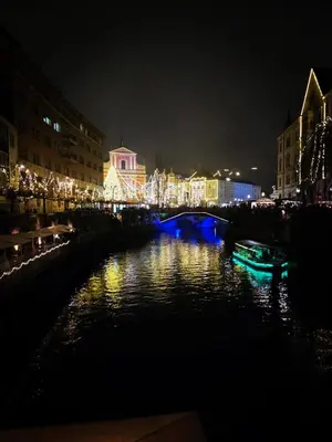 a bridge over a river at night with lights at Riverside Guesthouse in Ig