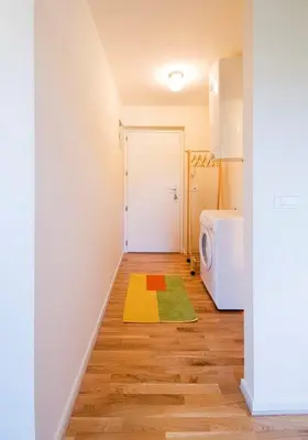 a hallway with a laundry room with a washing machine at Studio My Ljubljana Home in Ljubljana