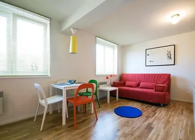 a living room with a red couch and a table and chairs at Studio My Ljubljana Home in Ljubljana