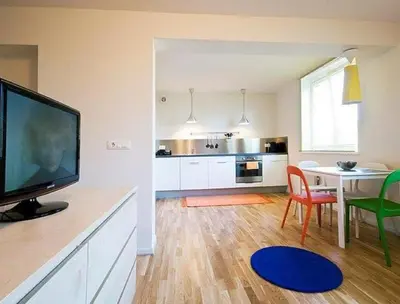 a living room with a television and a table with chairs at Studio My Ljubljana Home in Ljubljana