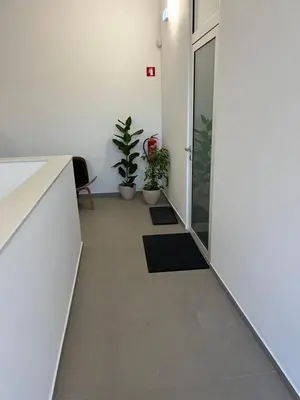 an office corridor with potted plants and a door at Diamant apartment pri sejmu MOS in Celje