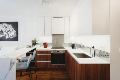 a kitchen with white cabinets and a sink at Romantic JUMP Studio overlooking river, free parking in Ljubljana