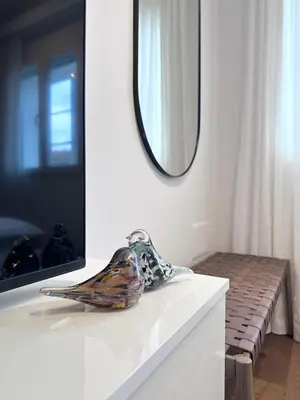a mirror on a white counter with a bird on it at Romantic JUMP Studio overlooking river, free parking in Ljubljana