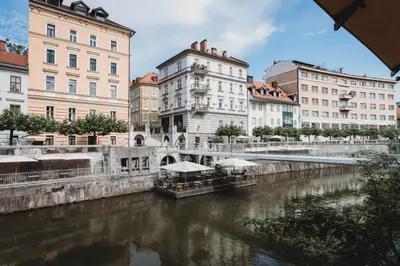 a river in a city with buildings and a bridge at Romantic JUMP Studio overlooking river, free parking in Ljubljana