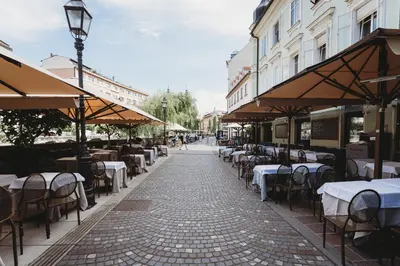 a street with tables and chairs on a sidewalk at Romantic JUMP Studio overlooking river, free parking in Ljubljana