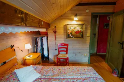 a bedroom with a bed and a chair in a room at Chalet Alpinka in Cerklje na Gorenjskem