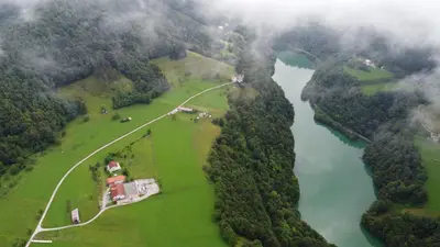 an aerial view of a river with a house and trees at Apartma Patricija for 2 in Tolmin