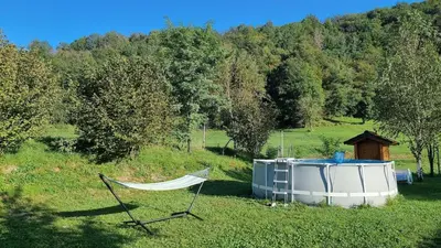 a boat and a hammock in a field at Apartma Patricija for 2 in Tolmin