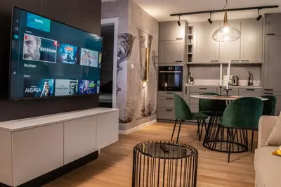 a kitchen and living room with a large screen tv at Ljubljana Urban Apartments - Quiet Stay & Free Parking in Ljubljana