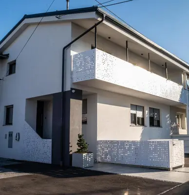 a white building with a balcony on the side of it at Ljubljana Urban Apartments - Quiet Stay & Free Parking in Ljubljana