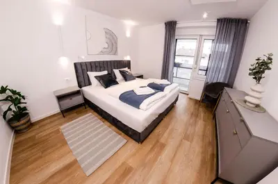 a bedroom with a large bed and a large window at Ljubljana Urban Apartments - Quiet Stay & Free Parking in Ljubljana