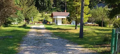a gravel road leading to a small white house at House Apartma Čebela with jacuzzi in Gozd Martuljek