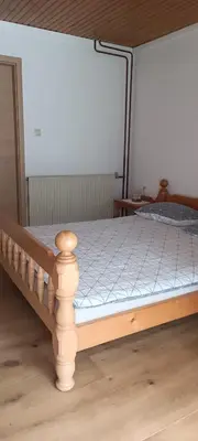 a bed in a room with a wooden frame at House Apartma Čebela with jacuzzi in Gozd Martuljek