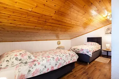 two beds in a room with a wooden ceiling at The Hug of Nature in Dekani