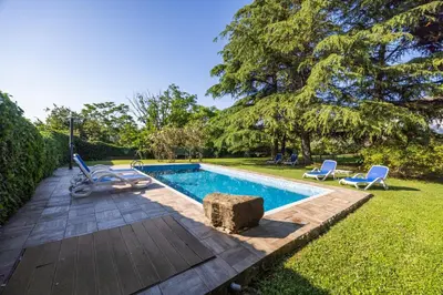 a swimming pool in a yard with chairs and a tree at The Hug of Nature in Dekani