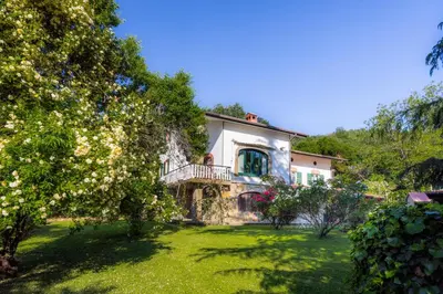 a large house with a balcony on a yard at The Hug of Nature in Dekani