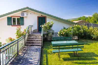 a house with two benches in the yard at The Hug of Nature in Dekani