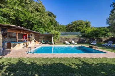 a swimming pool in a yard with two lawn chairs at The Hug of Nature in Dekani
