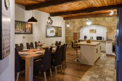a dining room with a table and a kitchen at The Hug of Nature in Dekani