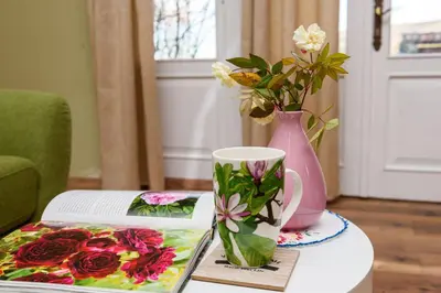 a table with a book and a vase and a coffee mug at The Hug of Nature in Dekani