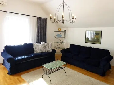 a living room with two blue couches and a table at Apartment Galerija in Radovljica