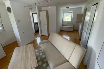 a living room with a white couch and a table at Family House Simba in Smarjeske Toplice