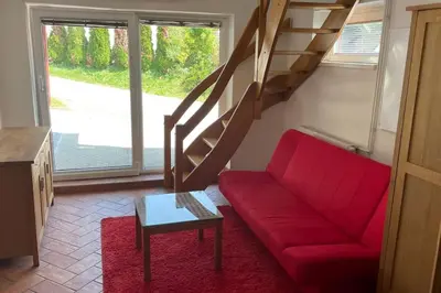 a living room with a red couch and a staircase at Family House Simba in Smarjeske Toplice