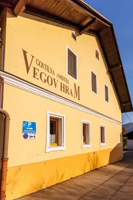 a building with a sign on the side of it at Hotel Vegov Hram in Dol pri Ljubljani