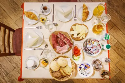 a table with plates of food and glasses of wine at Hotel Vegov Hram in Dol pri Ljubljani